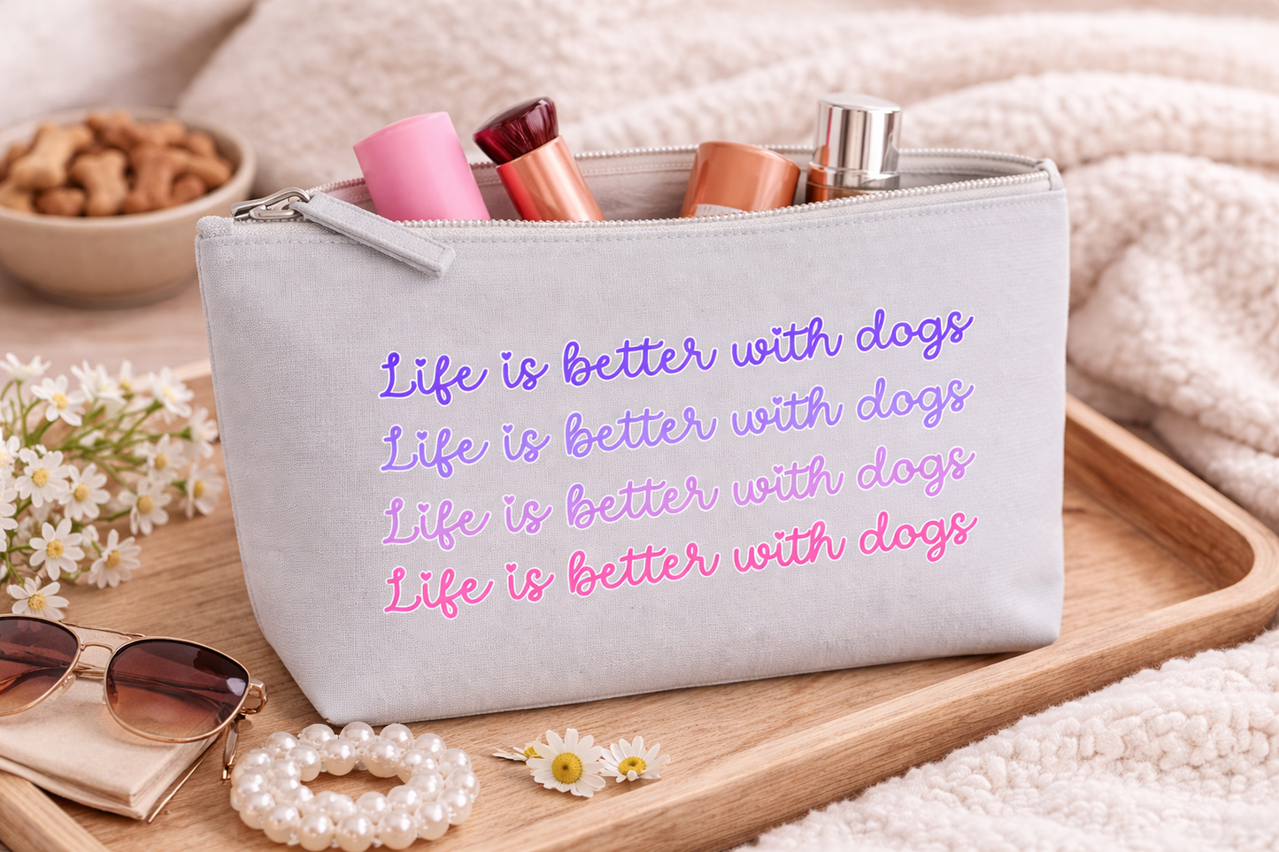 Grey pouch with 'Life is better with dogs' text on a wooden tray with accessories.