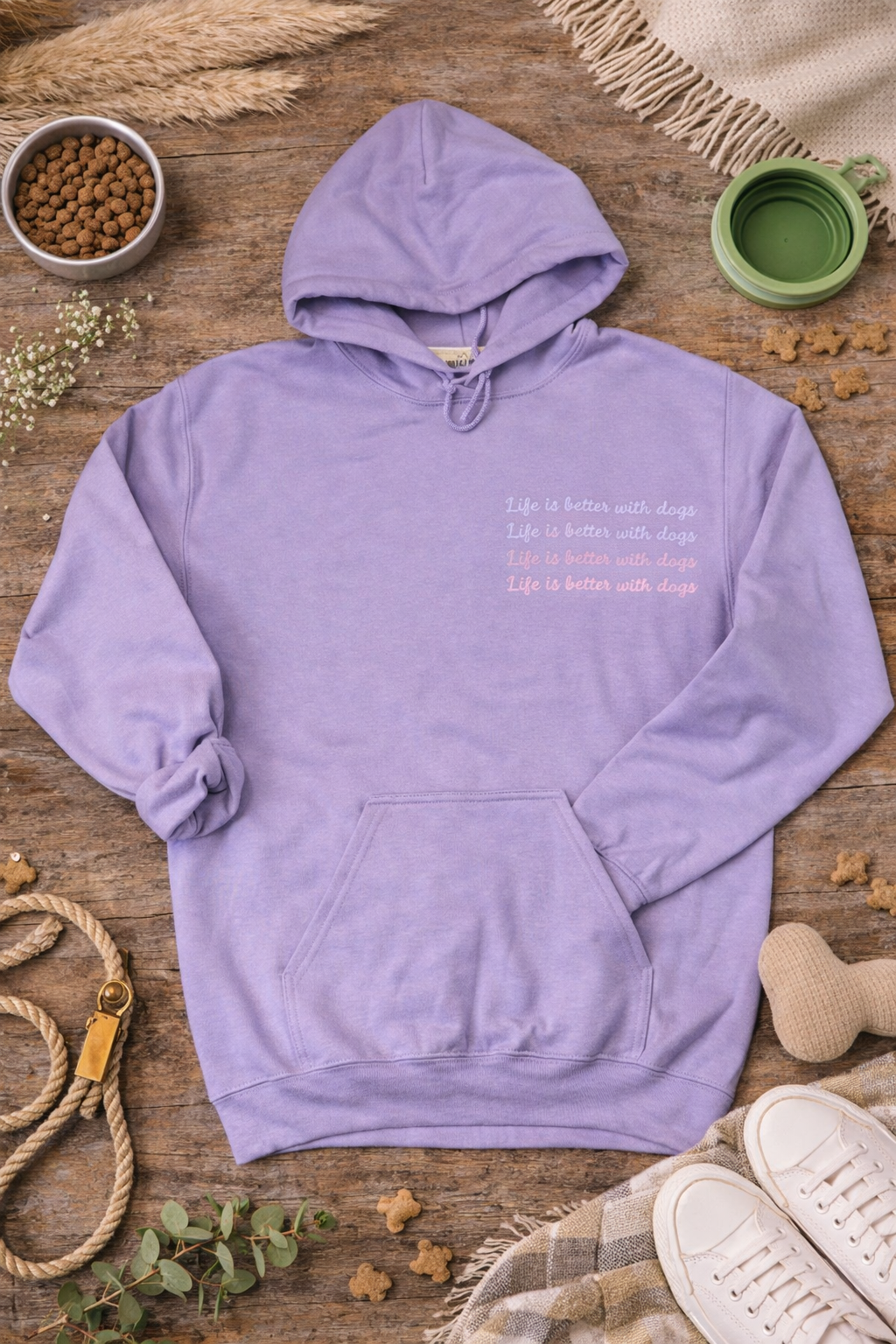 Purple hoodie with text on a wooden surface with pet-related items.